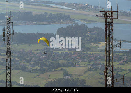 Gleitschirm im Flug mit bunten Flügel, Baldachin. Ansichten aus der Sicht der Pena Cabarga, Kantabrien, Spanien. Stockfoto