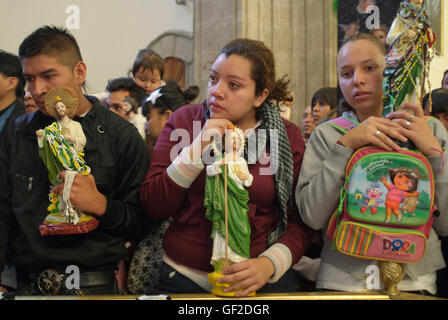 Anbeter mit Statuen und andere Artikel der Hingabe an Saint Jude Thaddeus, helfen bei einer Masse am Festtag des Heiligen. Stockfoto