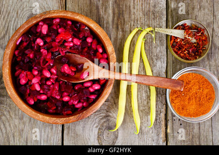 Vinaigrette mit Bohnen auf rohen Brettern Stockfoto