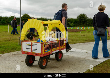 Carfest Nord, Bolesworth, Cheshire, UK. 29. Juli 2016. Zwei Kinder werden rund um den Ort auf der Rückseite einen Trolley transportiert. Die Veranstaltung ist die Idee von Chris Evans und Funktionen 3 Tage von Autos, Musik und Unterhaltung mit einem Gewinn an die Stiftung Kinder in Not gespendet. Bildnachweis: Andrew Paterson/Alamy Live-Nachrichten Stockfoto