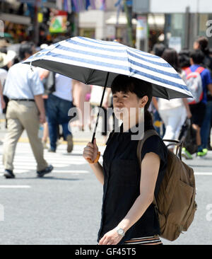 Tokio, Japan. 29. Juli 2016. Ein Fußgänger geht auf der Straße der Stadtteil Shibuya, Tokyo, Japan, am 29. Juli 2016. Die Temperatur überschritten 32 Grad Celsius in Tokio am Samstag. Bildnachweis: Ma Ping/Xinhua/Alamy Live-Nachrichten Stockfoto