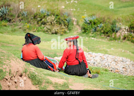 Zwei Anden indischen Frauen in ihren traditionellen Kostümen sitzen auf dem Rasen in Sacsayhuaman Stockfoto