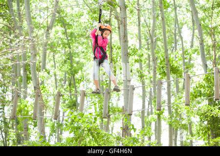 Chinesische Mädchen spielen im Tree Top Adventure park Stockfoto