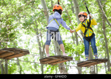 Glückliche chinesische Kinder spielen im Tree Top Adventure park Stockfoto