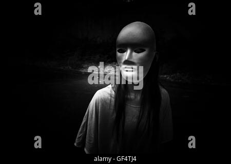 Geheimnisvolle Frau in schwarzem Kleid weiße Maske, beängstigend Hintergrund für Bucheinband Stockfoto