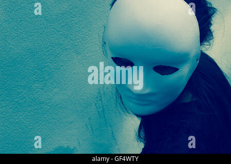 Geheimnisvolle Frau in schwarzem Kleid weiße Maske, beängstigend Hintergrund für Bucheinband Stockfoto