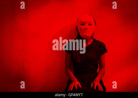 Geheimnisvolle Frau in schwarzem Kleid weiße Maske, beängstigend Hintergrund für Bucheinband Stockfoto