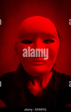 Geheimnisvolle Frau in schwarzem Kleid weiße Maske, beängstigend Hintergrund für Bucheinband Stockfoto