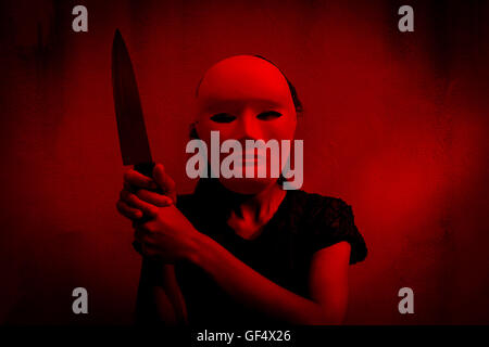 Geheimnisvolle Frau im schwarzen Kleid mit weißen Maske mit Messer, beängstigend Hintergrund für halloween Stockfoto