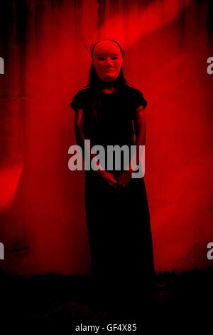 Geheimnisvolle Frau in schwarzem Kleid weiße Maske, beängstigend Hintergrund für Bucheinband Stockfoto
