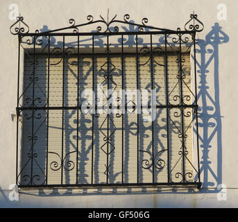 Wrought Iron Grill oder Bars am Fenster in Alora, Schatten Andalusien Casting auf Wand Stockfoto