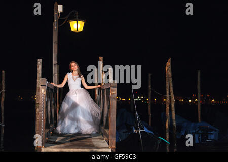 Braut-Porträt in der Nacht in der Nähe von Gondeln unter den Straßen Laterne in Venedig, Italien Stockfoto