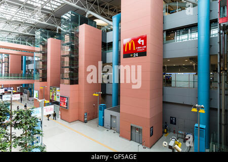 Flughafen Kansai, Japan. Interieur, Klemme 1. Allgemeine Ansicht entlang der Innenseite mit Menschen, die Innenwände der Abreise Böden und Gehwege. Stockfoto