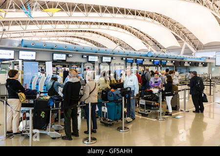 Japan, Kansai Airport, KIX. Interieur von Terminal 1. International check-in. Amerikanische Touristen Schlange am Check In Schalter für United Airlines Flug. Stockfoto