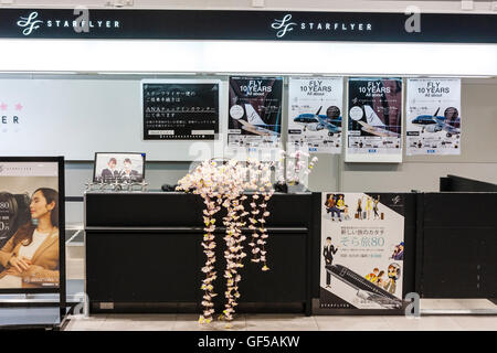 Japan, Osaka, Kansai Airport, KIX. Interieur von Terminal 1 Gebäude. International check-in. Leere Starflyer Schreibtisch mit Kunststoff Kirschblüten. Stockfoto