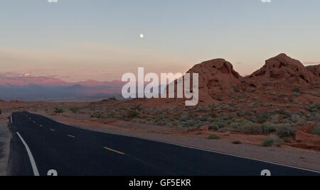 Der Mond aufgeht über die tief Orangen und kühle Blautöne des Valley of Fire State Park in Nevada, USA. Stockfoto