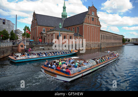 Das neue, nachhaltige Elektrokanal-Ausflugsboot, das an einem Netto-Diesel-Ausflugsboot in der Holmen's Church, Kopenhagen Inner Harbor, Dänemark vorbeiführt. Slotsholm Kanal. Stockfoto
