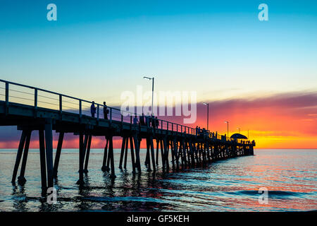 Menschen entspannen am Henley Beach bei Sonnenuntergang, South Australia. Stockfoto