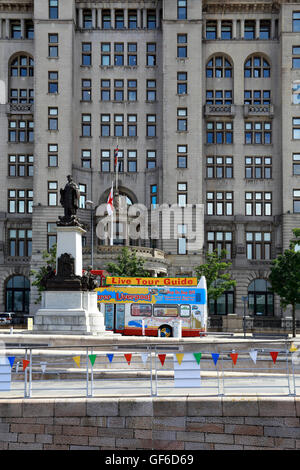 Open top tour bus vor dem Royal Liver Building, Liverpool, Merseyside, England, UK. Stockfoto