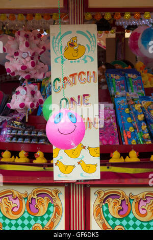 Rosa Smilng Gesicht Ballon auf einem traditionellen Haken einen Ente Festplatz stall Stockfoto