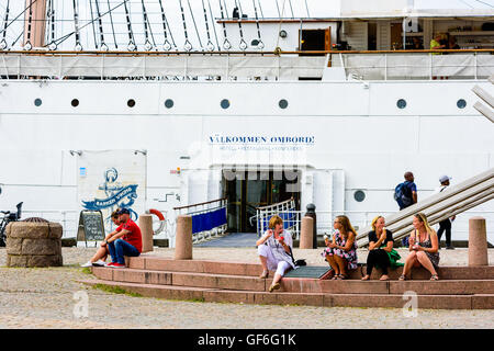 Göteborg, Schweden - Juli 25. 2016: Frauen sitzen auf ein Denkmal aus Stein Treppe sprechen und essen Eis. Eingang zu einer sailboa Stockfoto