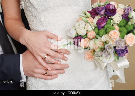 Hände-Braut und Bräutigam mit Ringen auf Taille Stockfoto