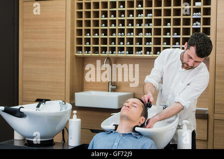 Nahaufnahme eines jungen Mannes, der seine Haare gewaschen im Friseursalon Stockfoto
