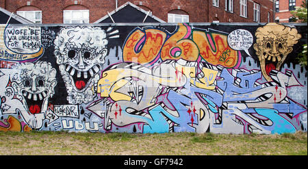 Kräftige Graffiti erhellen eine Mauer in Kopenhagen, Dänemark, und verleihen dem Straßenbild der Stadt lebendige Farben und urbane Kreativität. Stockfoto