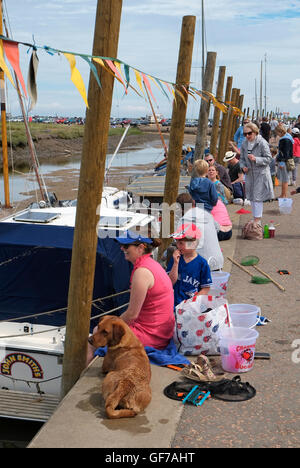 Menschen sitzen auf Blakeney Hafen, North Norfolk, england Stockfoto