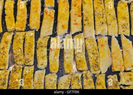 Rohteig gesalzener Käse Blätterteig-sticks mit Pfeffer und provenzalischen Kräutern Closeup auf Backblech Stockfoto