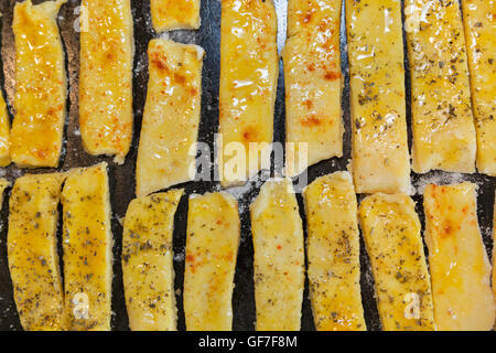 Rohteig gesalzener Käse Blätterteig-sticks mit Pfeffer und provenzalischen Kräutern Closeup auf Backblech Stockfoto