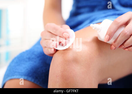 Weibliche desinfiziert die Wunde am Knie mit Sauerstoff angereichertes Wasser gießen. Stockfoto