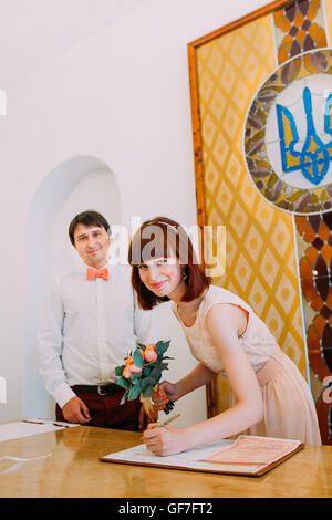Hochzeits-Zeremonie. Braut und Bräutigam Heiratsurkunde oder Vertrag zu unterzeichnen Stockfoto