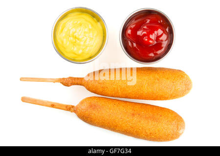 Zwei Corndogs mit Senf und Ketchup auf der Seite.  Isoliert auf weißem Hintergrund. Stockfoto