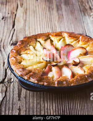 Hausgemachter Apfelkuchen gekocht in einer Pfanne erhitzen und die Reifen Äpfel auf rustikalen Holztisch Stockfoto