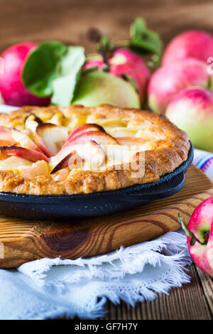 Hausgemachter Apfelkuchen gekocht in einer Pfanne erhitzen und die Reifen Äpfel auf rustikalen Holztisch Stockfoto