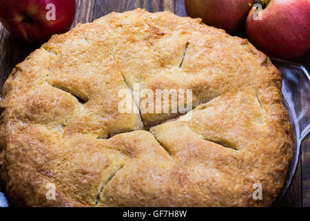 Hausgemachter Apfelkuchen mit Blätterteig Tortenboden und geschnittenen Äpfel, Zucker, Piment, Zimt, Vanille auf rustikalen Holztisch Stockfoto