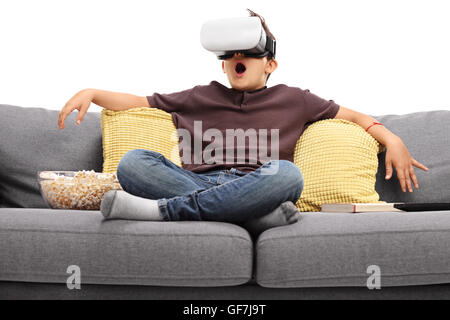 Erstaunt Zicklein mit virtual-Reality-Brille sitzt auf einem Sofa isoliert auf weißem Hintergrund Stockfoto