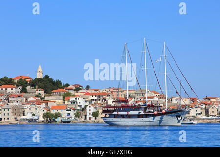 Eine Yacht voller Touristen auf der Suche nach einem Liegeplatz in Primosten, Kroatien Stockfoto