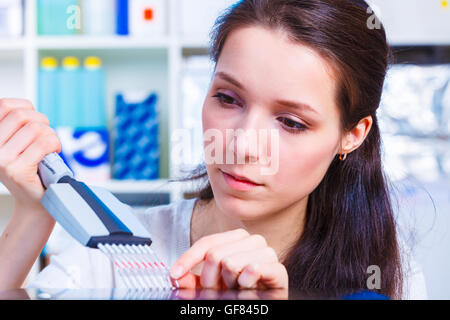 medizinische oder wissenschaftliche Forscher oder Arzt arbeitet mit einer Pipette, biologischen Proben und ein gut Tablett in einem Labor Stockfoto