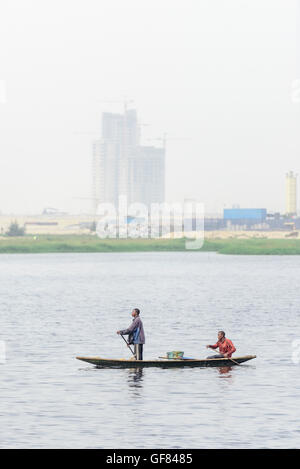 Fischer in Einbaum Kanu Reihe Gebäude in neue Eko Atlantic Stadtentwicklung, Lagos, Nigeria. Stockfoto