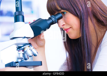 Studentin sucht in einem Mikroskop, Wissenschaft Labor Konzept Stockfoto