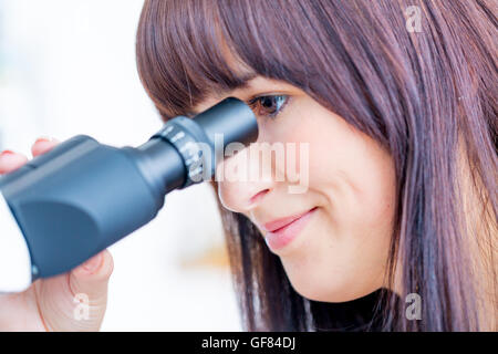 Studentin sucht in einem Mikroskop, Wissenschaft Labor Konzept Stockfoto