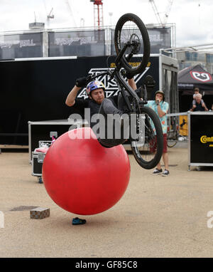 Schottische Studien Radfahrer Danny Macaskill zeigt seine Fähigkeiten bei einem Drop and Roll Display, während die aufsichtsrechtlichen RideLondon Grand Prix in Lee Valley VeloPark, Queen Elizabeth Olympic Park in London. Stockfoto