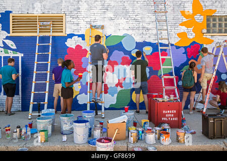 Detroit, Michigan - Junge Freiwillige Farbe auf die Wand einer Münzwaschmaschine im Morningside Nachbarschaft. Stockfoto