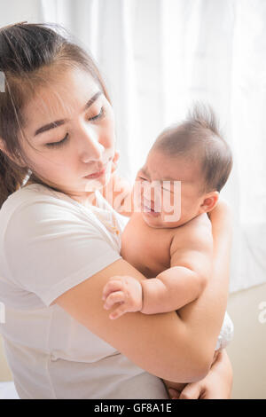 Mutter Holding entzückenden Kind Baby junge Baby weint Stockfoto