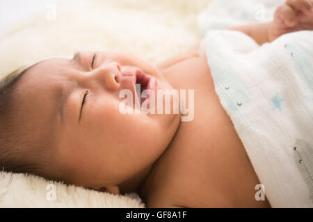 kleine asiatische Baby weint auf Bett Stockfoto