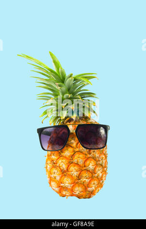 Ananas mit Sonnenbrille - Sommer Urlaub Ferien essen gesundes Konzept Bild auf blauem Hintergrund Stockfoto