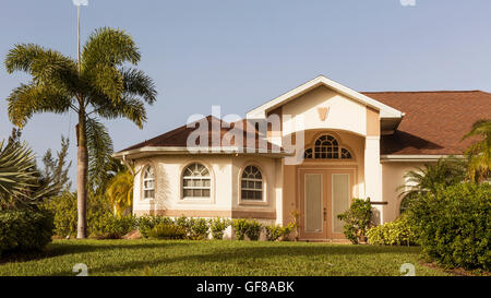 Typische Südwestflorida Betonblock und Stuck zu Hause, in der Landschaft mit Palmen, tropischen Pflanzen und Blumen, Rasen Stockfoto