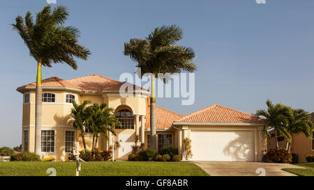 Typische Südwestflorida Betonblock und Stuck zu Hause, in der Landschaft mit Palmen, tropischen Pflanzen und Blumen, Rasen Stockfoto